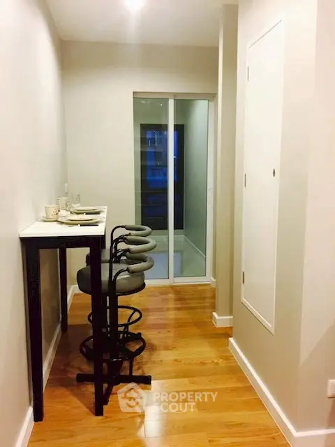 Modern hallway with sleek bar stools and wooden flooring