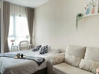 Cozy bedroom with natural light, stylish decor, and comfortable seating area.
