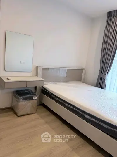 Modern bedroom with sleek furniture and large window for natural light.