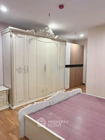 Elegant bedroom with ornate wardrobe and stylish bed frame in modern apartment.