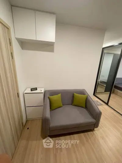 Cozy modern living room with stylish gray sofa and green cushions, perfect for relaxation.