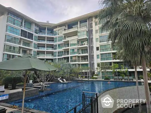 Luxurious condominium with stunning pool and lush greenery, perfect for modern living.