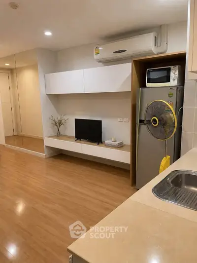 Modern living room with sleek design, featuring built-in TV unit and air conditioning, perfect for urban living.