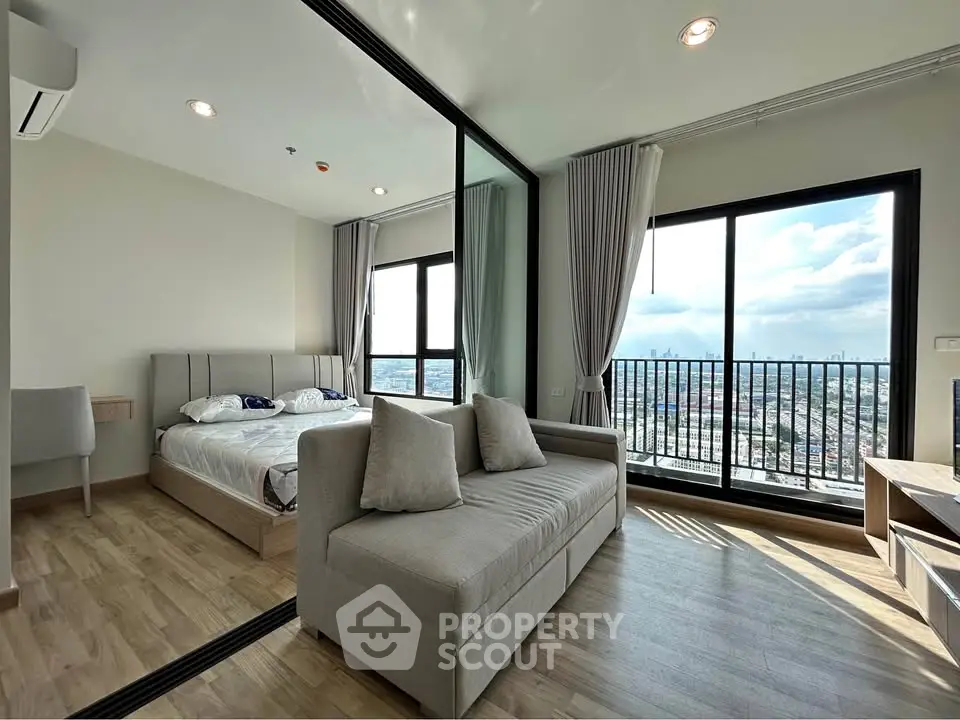 Modern apartment with spacious living room and bedroom, featuring large windows and stunning city view.