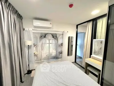 Modern bedroom with elegant decor and large window, featuring a stylish vanity and ample natural light.