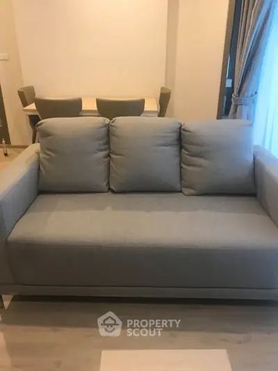 Modern living room with cozy gray sofa and elegant dining area