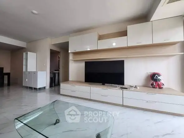 Spacious living room with modern TV unit and glass coffee table