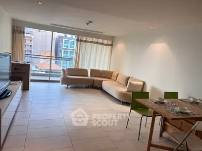 Spacious living room with modern furniture and large windows offering city views.