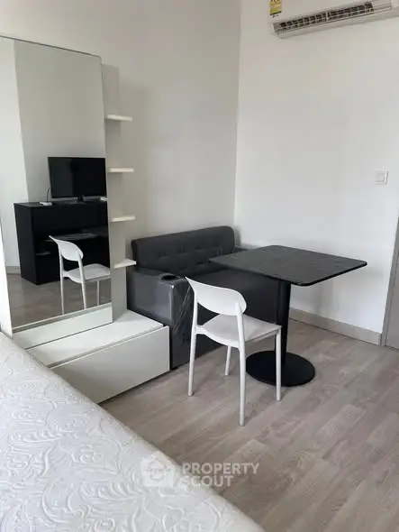 Modern compact living space with dining area and mirror