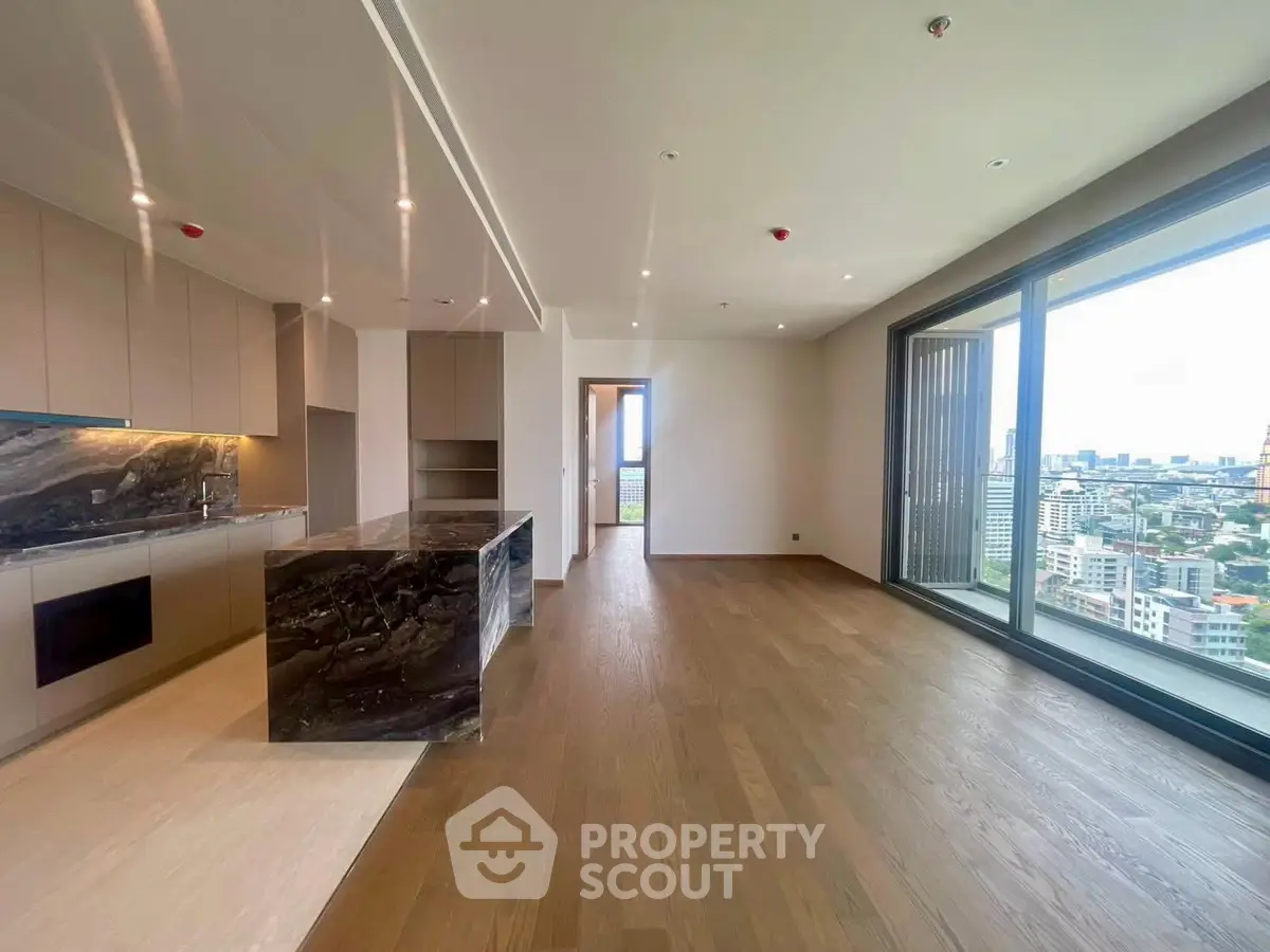 Luxurious open-plan living room with stunning city view and modern kitchen design.