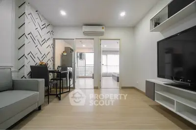 Modern living room with stylish decor and open layout leading to bedroom and balcony.