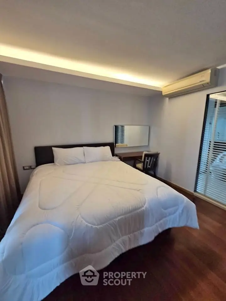 Cozy bedroom with modern decor and ample natural light, featuring a comfortable bed and stylish furnishings.