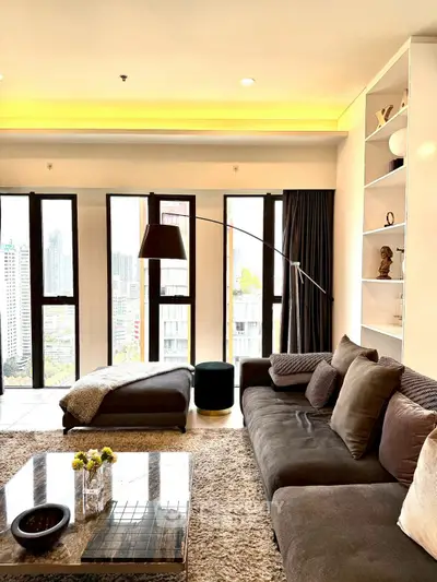Luxurious living room with panoramic city view, plush sofa, and elegant decor in a high-rise apartment.