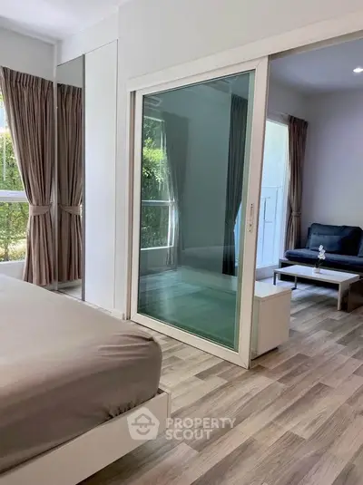 Modern bedroom with sliding glass door and cozy living area