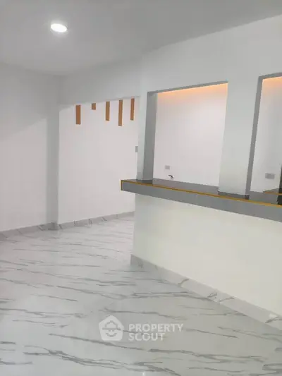 Modern open layout with sleek marble flooring and stylish partition wall in a contemporary home.