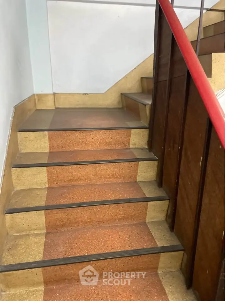Charming vintage staircase with wooden railing and retro flooring in a classic building.