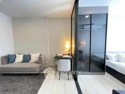 Modern studio apartment with cozy living area and glass partitioned bedroom, ideal for urban living.
