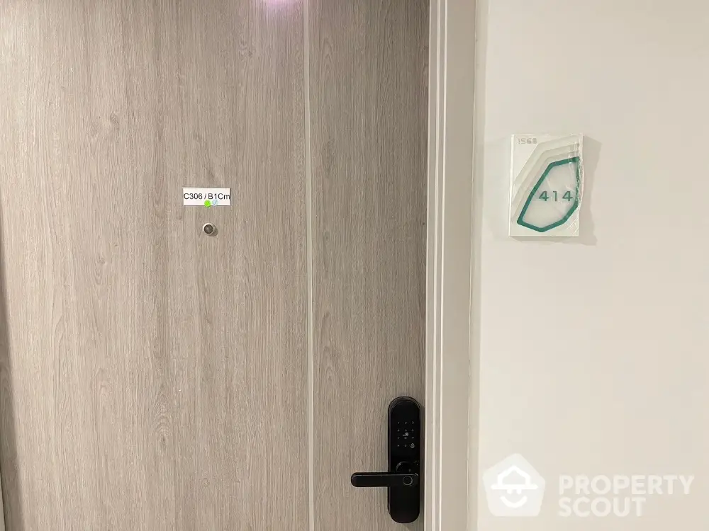 Modern apartment door with digital lock and room number signage