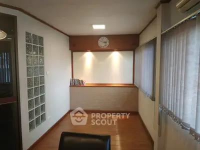 Spacious study room with wooden flooring and ample natural light