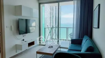 Modern living room with ocean view and balcony access in high-rise apartment.