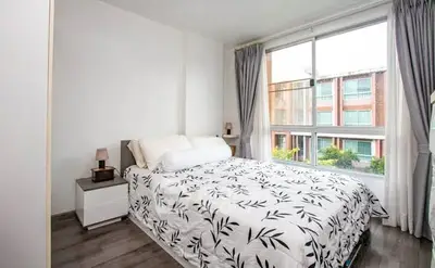 Bright bedroom with large window and modern decor in urban apartment
