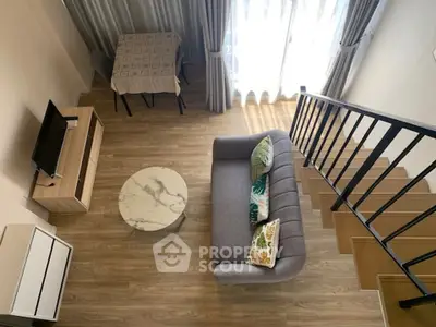 Modern loft-style living room with cozy sofa, TV, and elegant decor