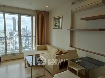 Modern living room with city view, featuring sleek furniture and large windows.
