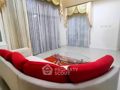 Spacious living room with elegant curtains and modern red sofa set