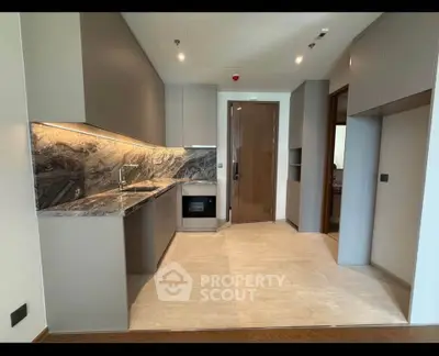 Modern kitchen with sleek cabinetry and marble countertops in a luxury apartment.