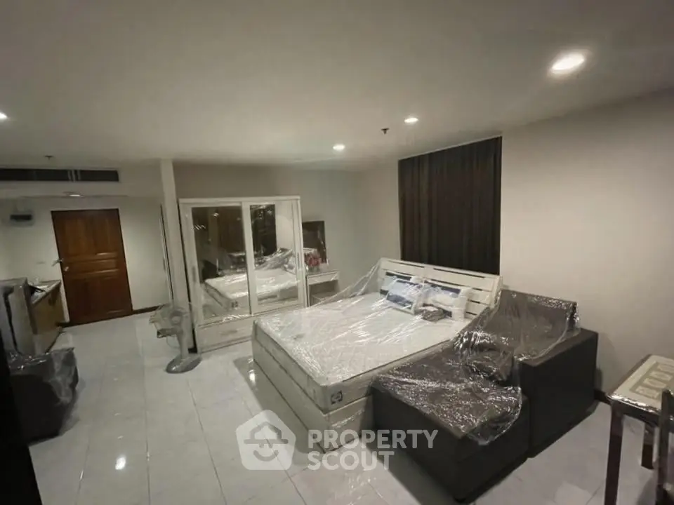 Spacious bedroom with modern furnishings and ample lighting, perfect for comfortable living.