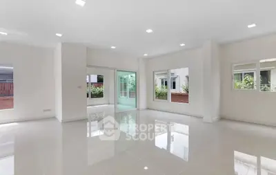 Spacious modern living room with large windows and glossy tiled floors