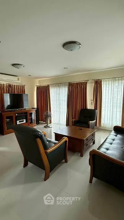 Spacious living room with elegant furniture and natural light, perfect for relaxation and entertainment.
