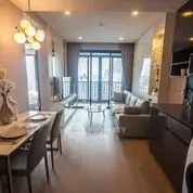 Modern living room with elegant decor and open layout, featuring a cozy sofa and dining area.