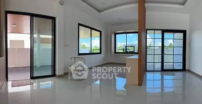 Spacious modern living room with large windows and glossy floors