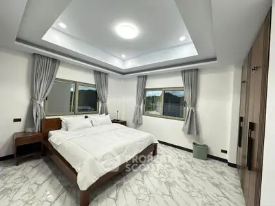 Spacious modern bedroom with elegant decor and large windows offering natural light.