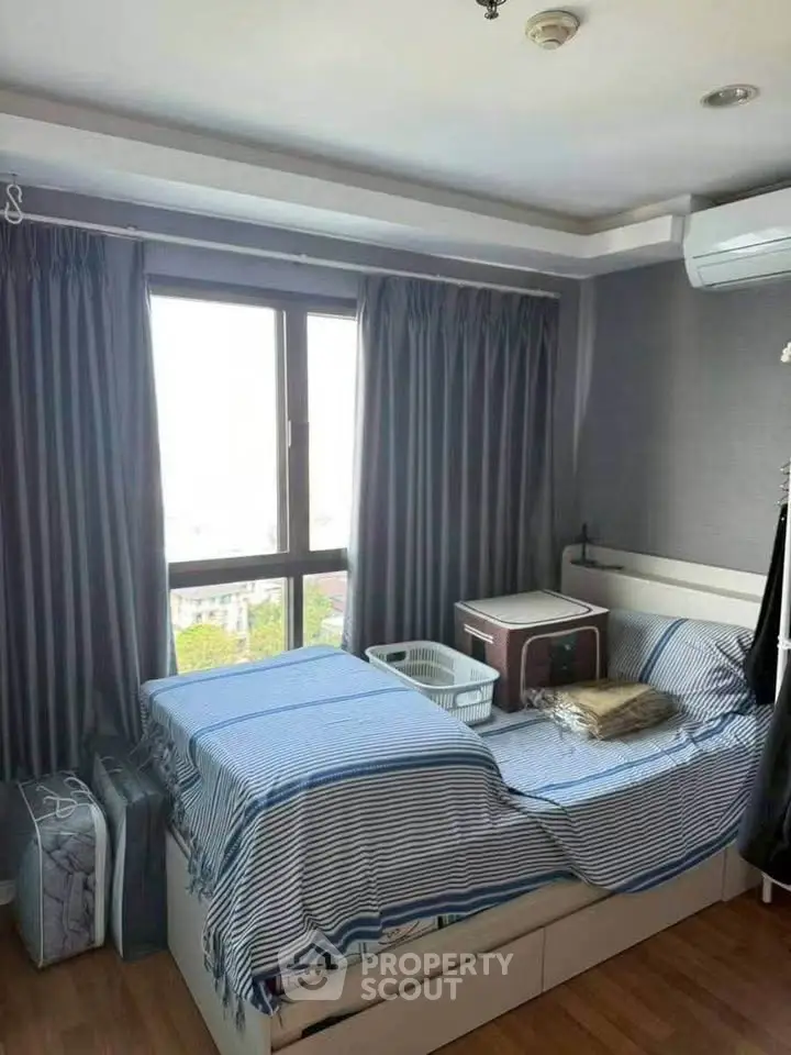 Cozy bedroom with large window and modern decor in urban apartment