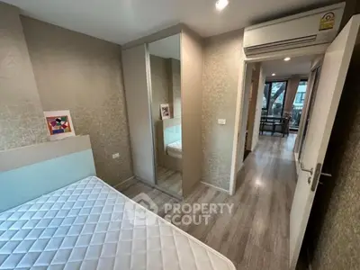 Modern bedroom with mirrored wardrobe and air conditioning in stylish apartment.