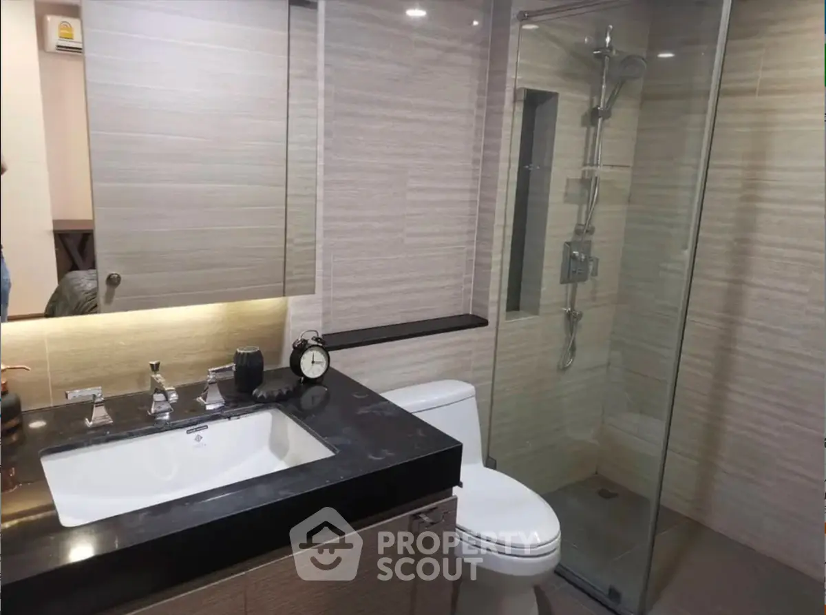 Modern bathroom with sleek design and glass shower enclosure.