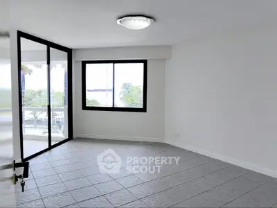 Spacious empty room with large windows and tiled floor, ideal for customization.