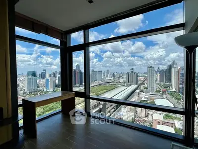 Stunning cityscape view from modern high-rise apartment with floor-to-ceiling windows.