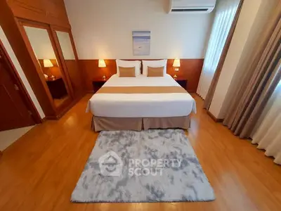Spacious bedroom with elegant decor and cozy ambiance, featuring a large bed and stylish lighting.