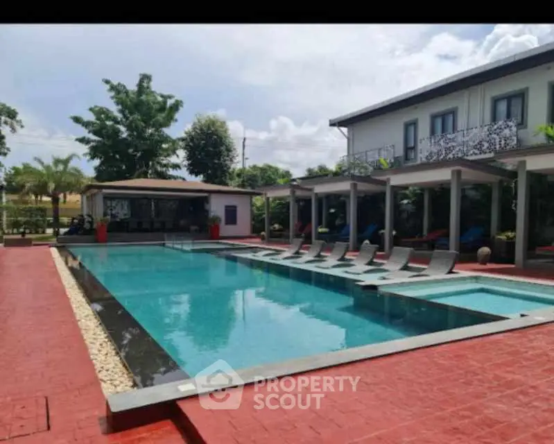 Luxurious outdoor pool area with modern design and sun loungers in a serene setting.