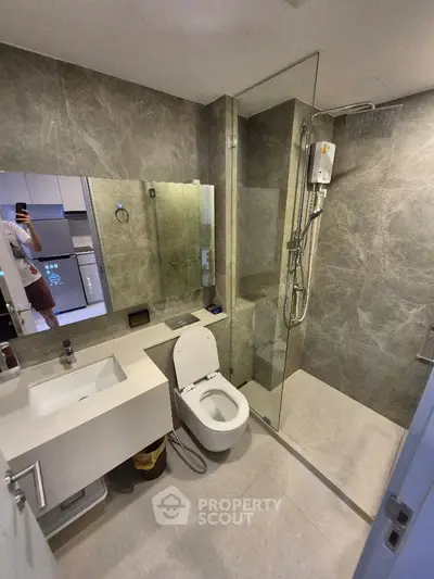 Modern bathroom with sleek design, glass shower, and elegant fixtures in a contemporary apartment.