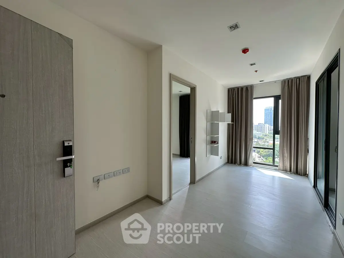 Spacious modern apartment interior with large windows and city view, ideal for urban living.