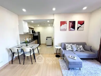 Modern open-plan living room with stylish decor and kitchen area