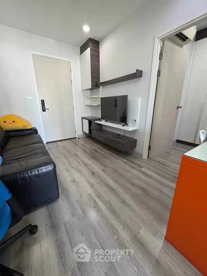 Modern living room with sleek flooring and stylish furniture in a cozy apartment.