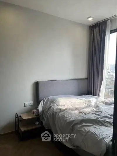 Cozy bedroom with natural light and modern decor, perfect for relaxation.