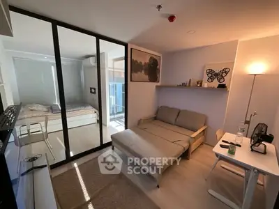Modern studio apartment with glass partition, cozy living area, and natural light.