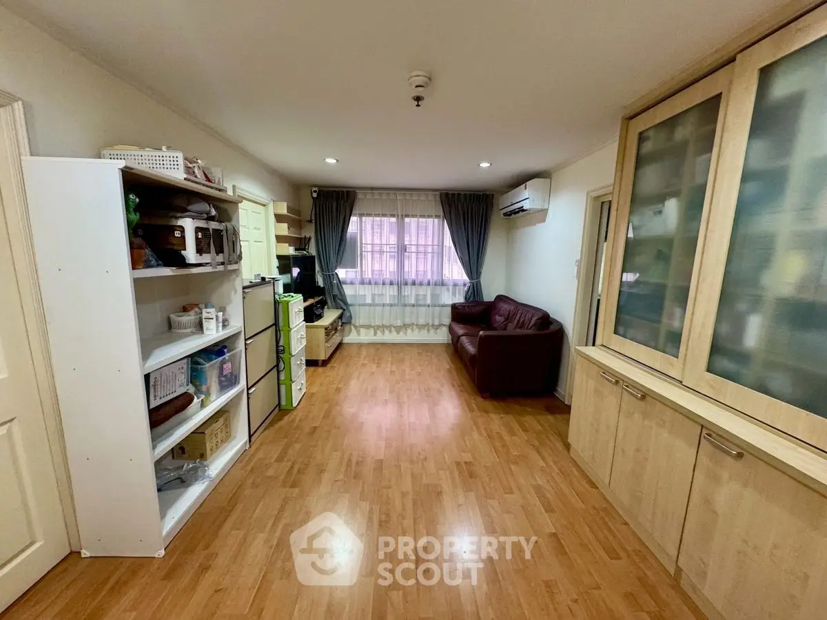Spacious living room with wooden flooring and modern furnishings, perfect for family gatherings.