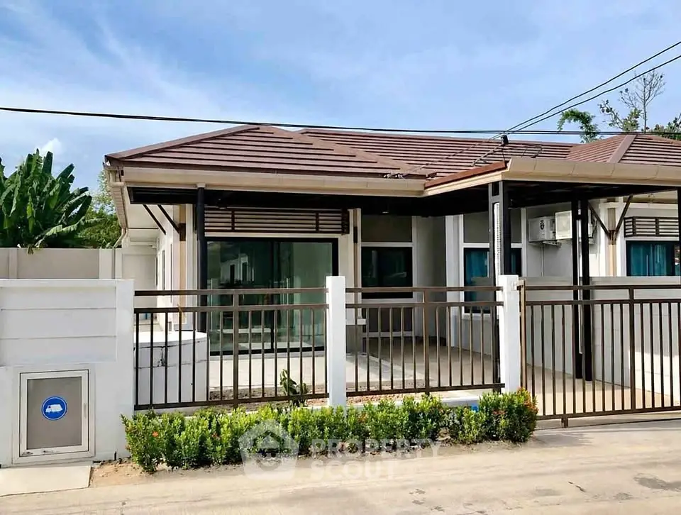 Charming single-story house with modern design and lush greenery, perfect for family living.